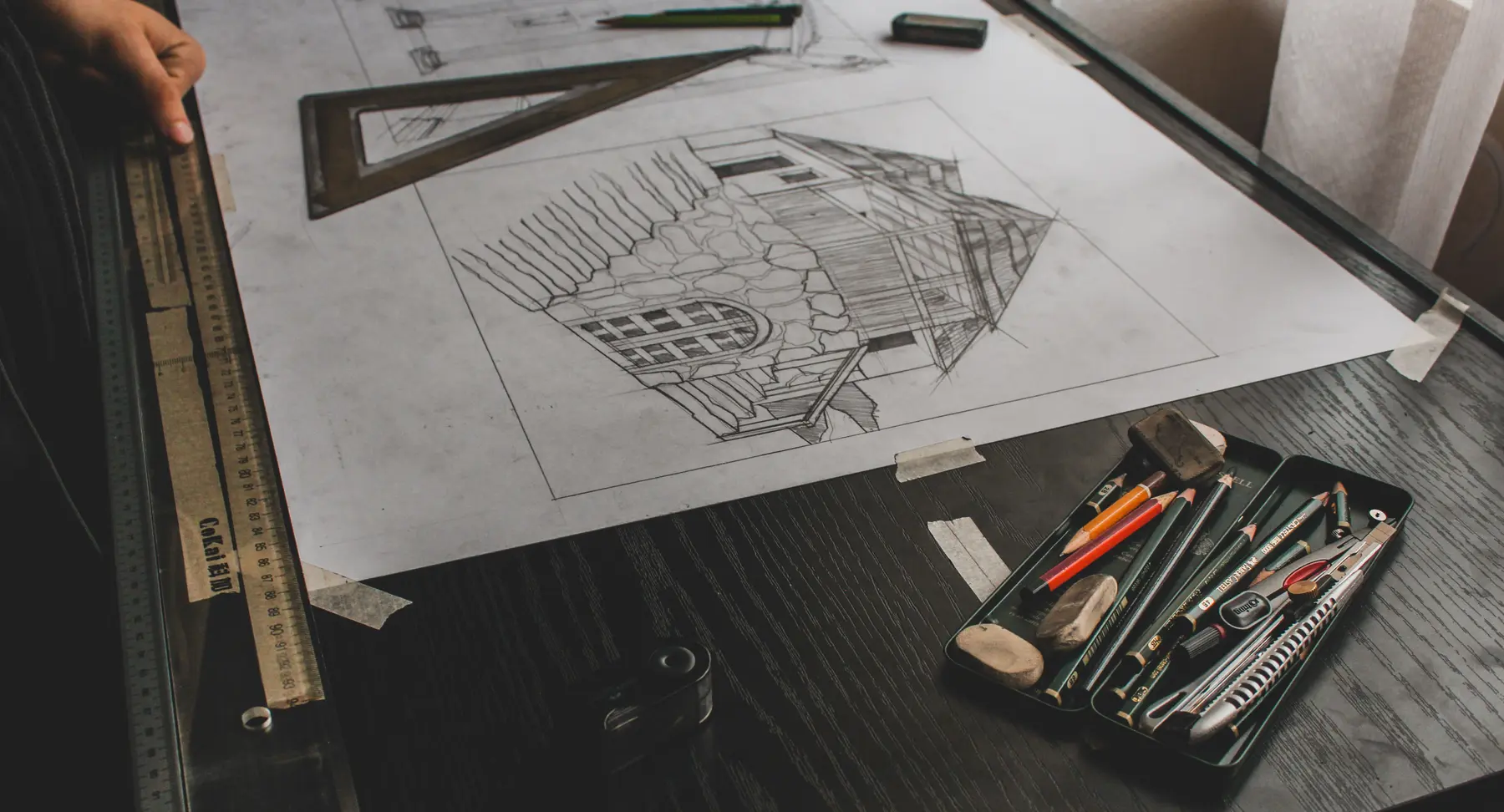 Architectural plans and drafting tools arranged on a worktable