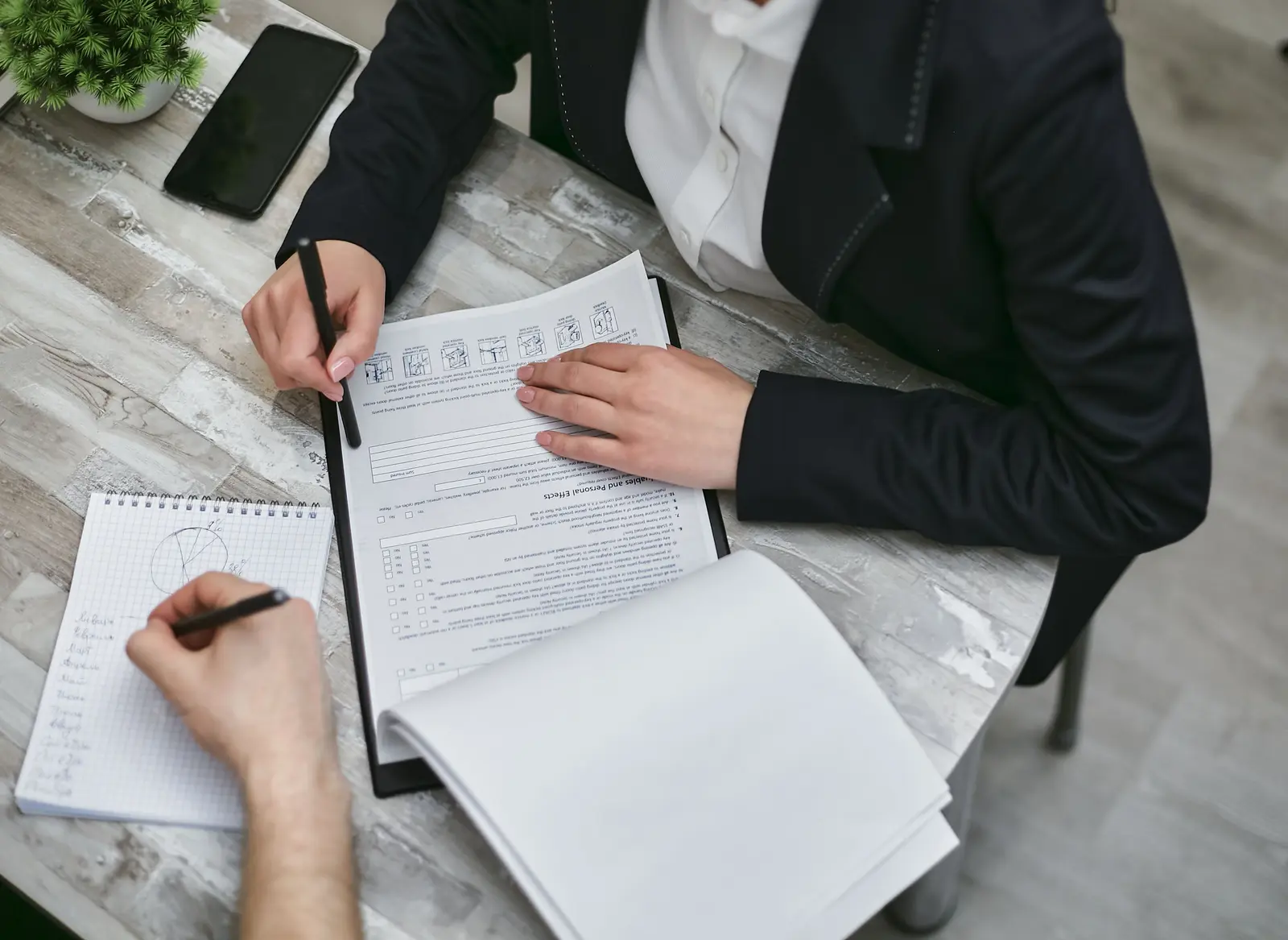 Two people reviewing documents and making notes together